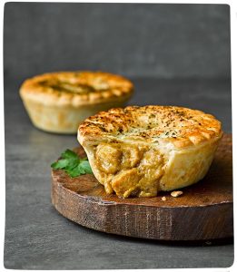A butter chicken premium pie pastry on a board